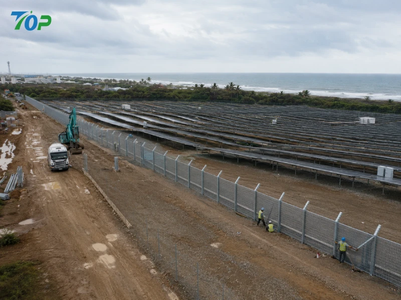 EPC contractors installing modular solar fencing systems at a coastal utility-scale photovoltaic power plant using galvanized steel fence structures